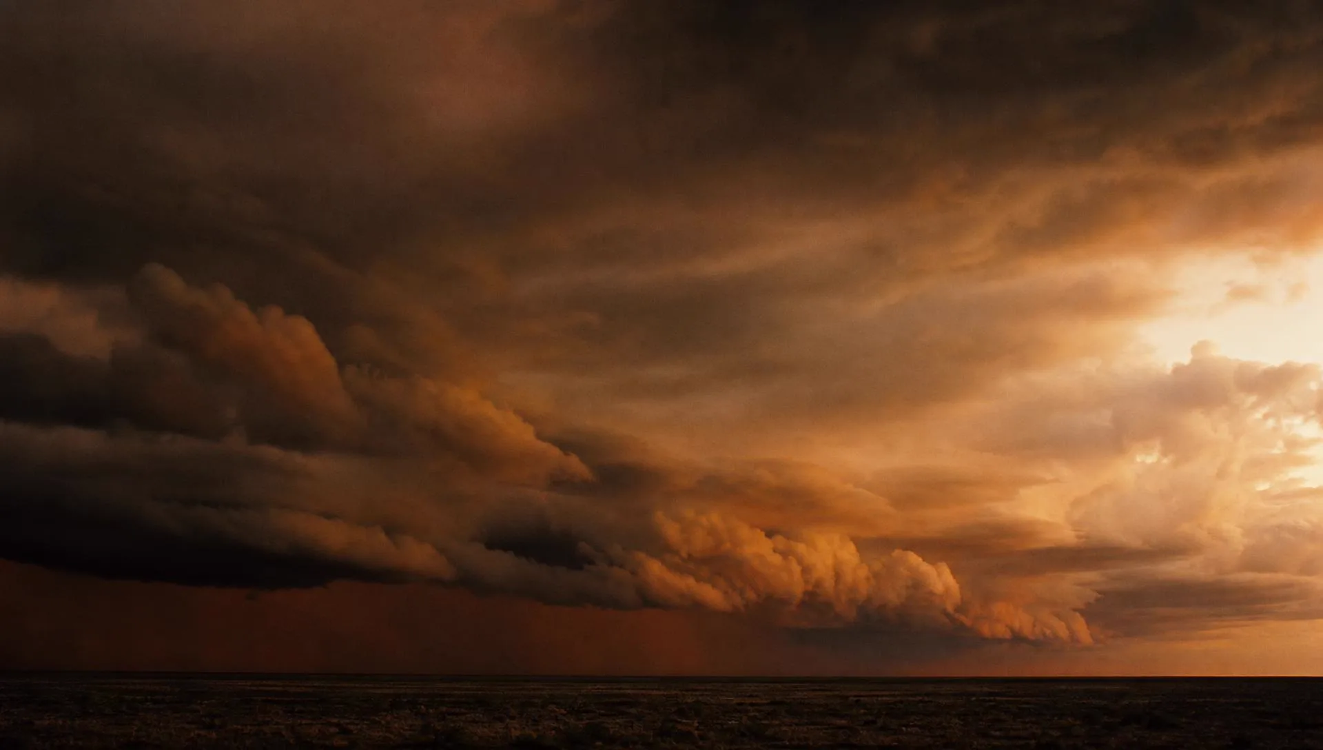 A low bank of cloud rolling across a flat horizon