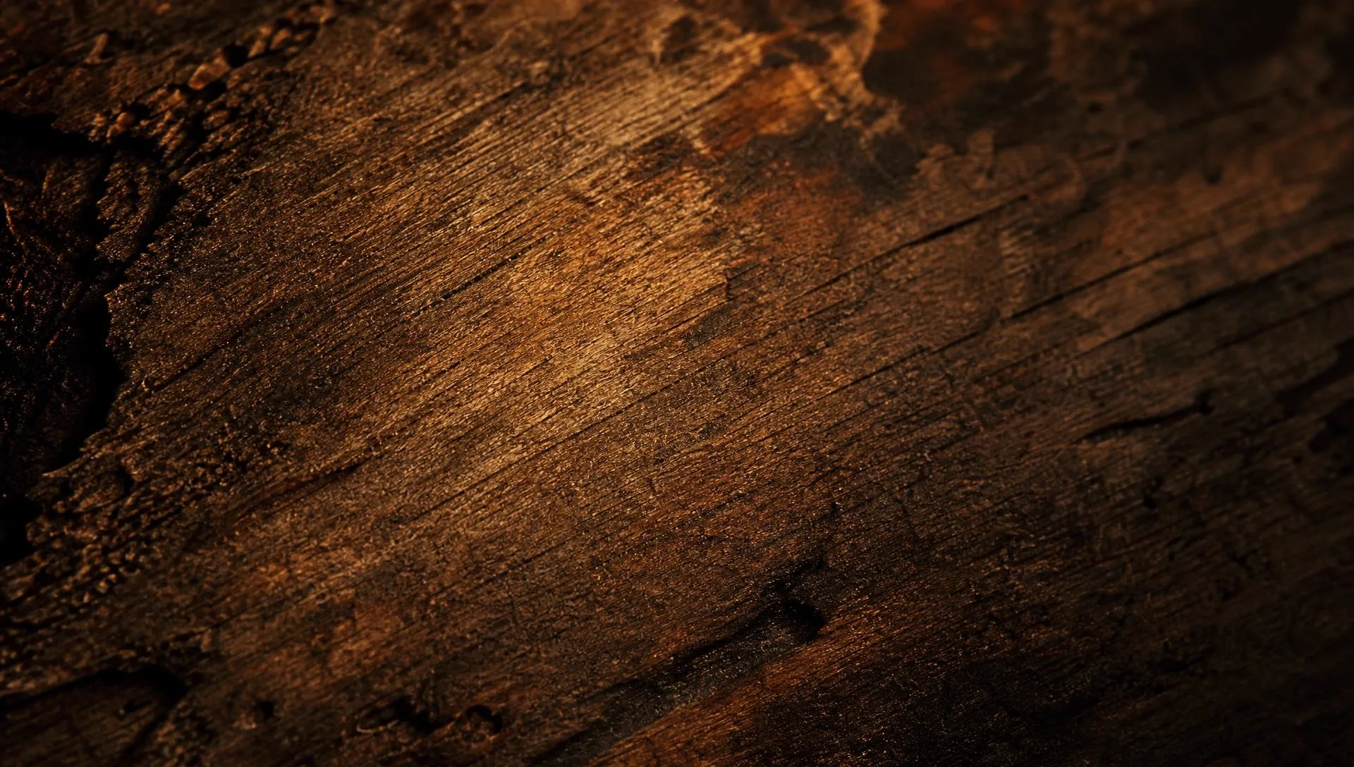 Worn dark wood grain lit by a single low lamp